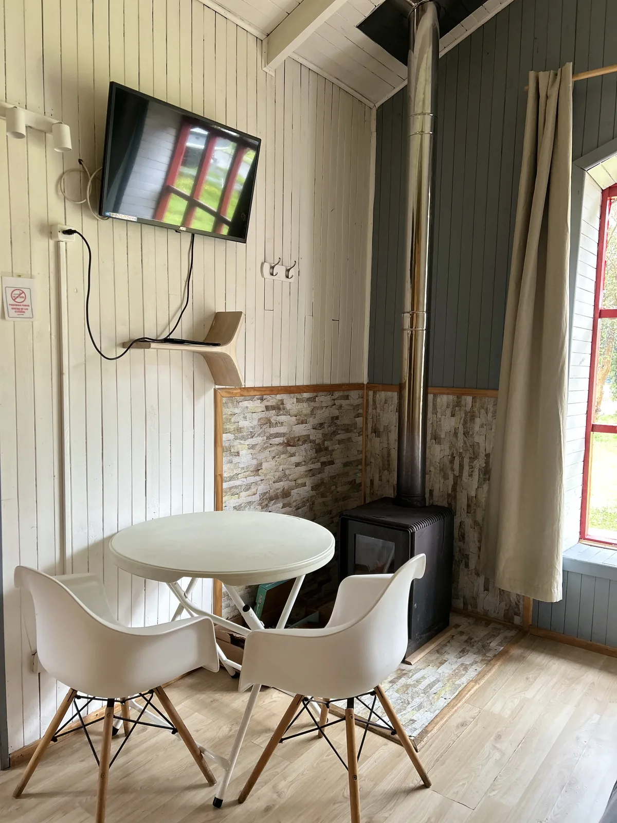 Living comedor de la Cabaña Ulmo — mesa, sillas y estufa a leña