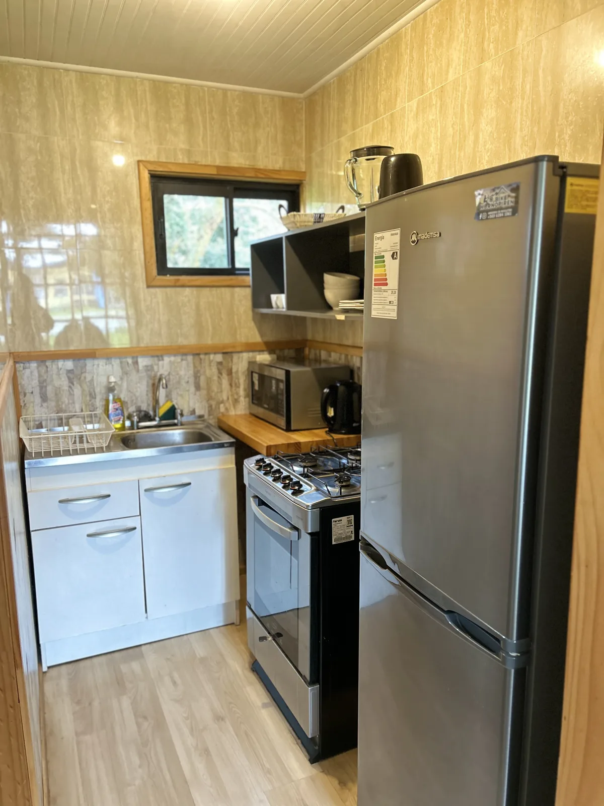 Cocina equipada de la Cabaña Ulmo — refrigerador, microondas y cocina a gas